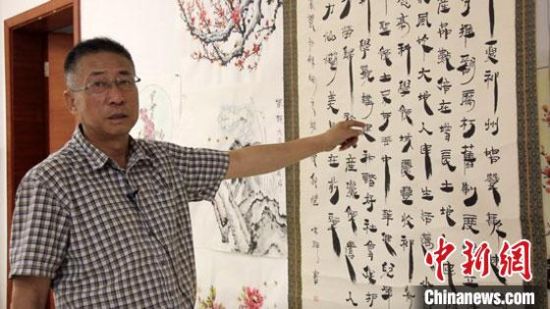 圖為朱群和他的敦煌漢簡(jiǎn)書(shū)體?！「攥?攝