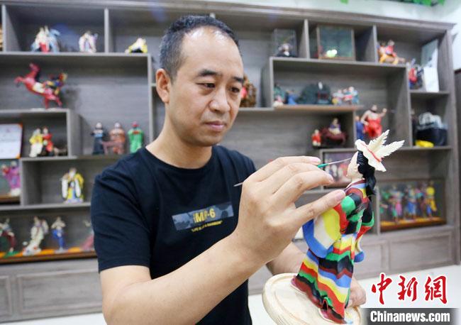 圖為安秋平正在創(chuàng)作代表隴南文縣民俗的《白馬人》作品?！「哒?攝