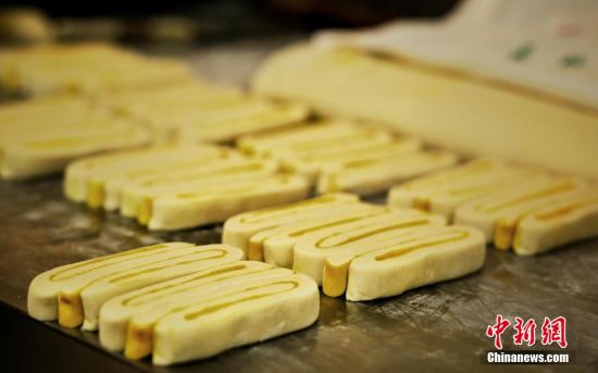 圖為面劑被涂上胡麻油，切成條狀用作月餅的花型制作。張文 攝