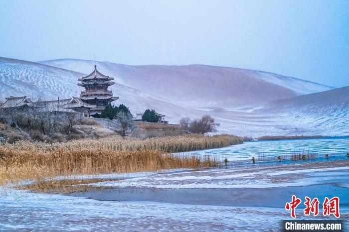 2021年11月28日，雪落鳴沙山月牙泉景區(qū)?！⊥醣筱y 攝