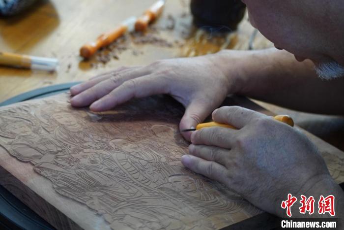 圖為徐晉林湊近木板，近距離制作雕版畫?！【琶赖┰?　攝