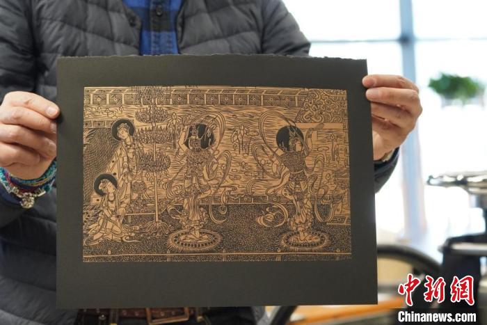圖為手工書藝人展示敦煌雕版壁畫印刷品?！【琶赖┰?　攝