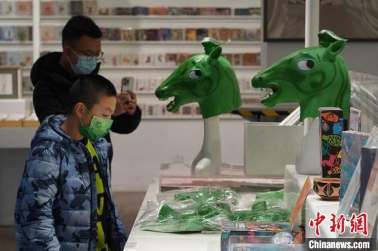 圖為“神馬來了”銅奔馬頭套吸引參觀者駐足?！【琶赖┰?攝