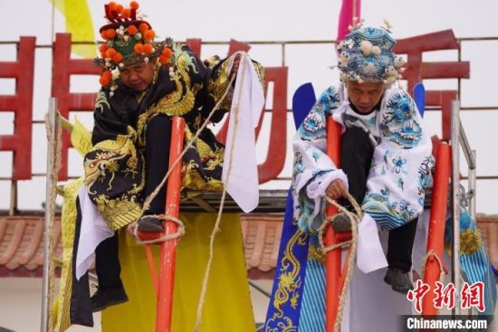 圖為“苦水高高蹺”表演者通過(guò)麻繩將腳固定在腳踏板，并在腿部纏繞六七圈?！【琶赖┰?攝