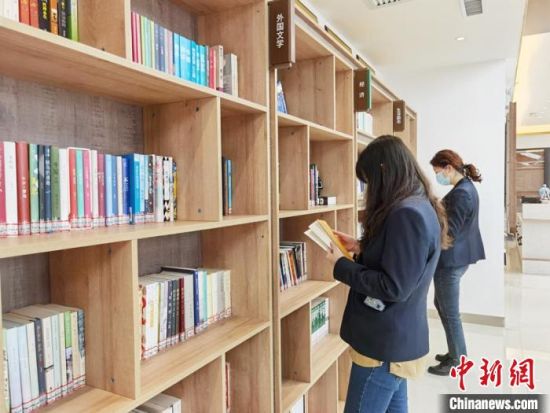 圖為在甘肅公航旅建設(shè)集團(tuán)有限公司的職工書屋，職工挑選書籍?！⌒煅?攝