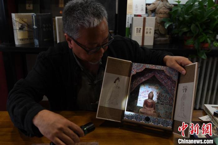 圖為讀者出版集團(tuán)讀者晉林工作室獨(dú)立出品人徐晉林，展示互動性強(qiáng)的敦煌題材手工書。(資料圖) 楊艷敏 攝