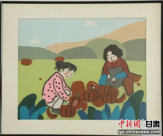 嘉峪關(guān)市新城鎮(zhèn)新城村農(nóng)業(yè)產(chǎn)業(yè)園區(qū)內(nèi)，母女兩人在摘南瓜。刺繡 馬艾米乃 繡稿 敬紅霞