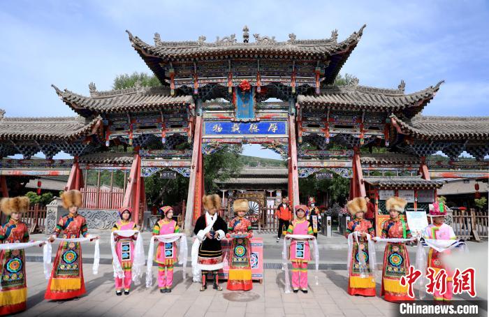 圖為身穿土族服飾的工作人員迎接訪客?！⊙Φ?攝