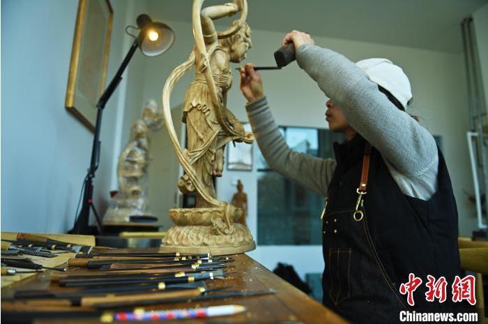 圖為季茂杰進行敦煌元素的木雕創(chuàng)作。李亞龍 攝</p>
<p>