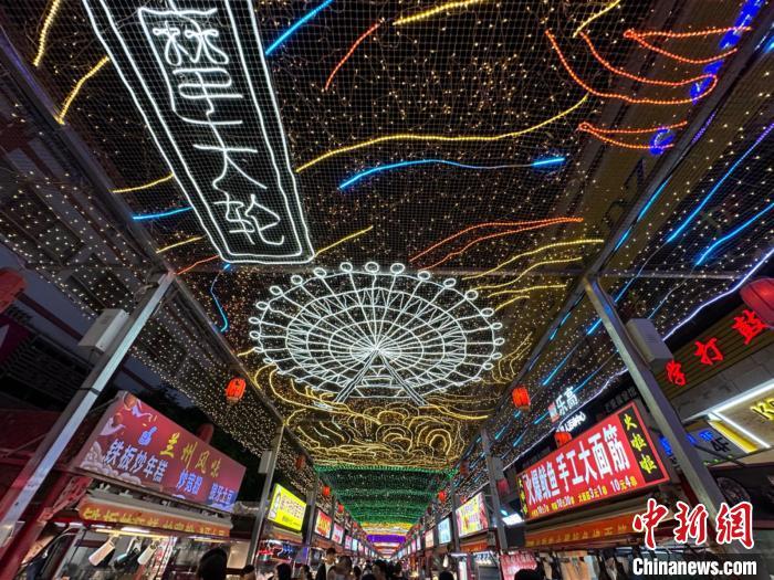 圖為明清街夜市燈光點(diǎn)亮具有武威文化元素的“摩天輪”彩燈。　戴文昌 攝</p><p>