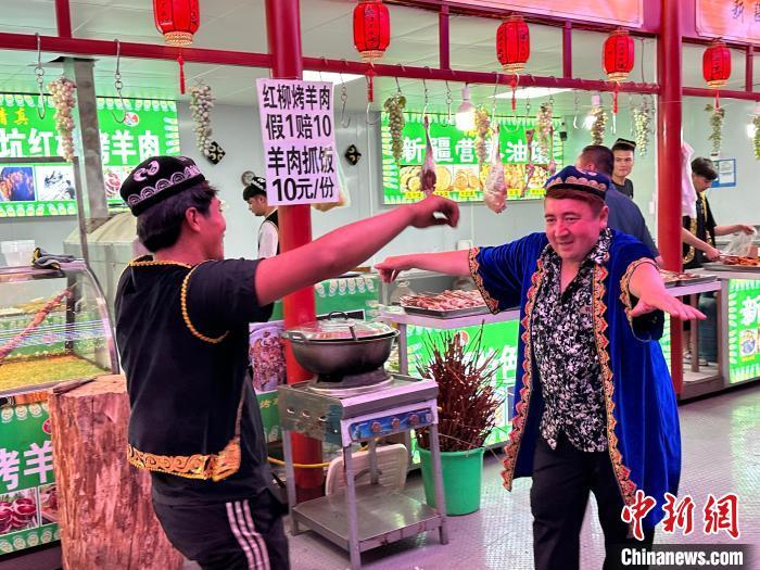 圖為餐飲經(jīng)營(yíng)者在“西涼不夜城”跳起舞蹈引客?！〈魑牟?攝</p><p>