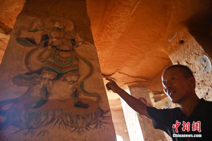 7月15日，甘肅省平?jīng)鍪袥艽h百里石窟長廊羅漢洞石窟內(nèi)，該窟文保員郭建平介紹窟內(nèi)石刻彩繪壁畫。郭建平家中三代人曾自發(fā)保護(hù)羅漢洞石窟。羅漢洞石窟遺存40余個窟龕，以北魏至清代風(fēng)格為主。中新社記者 李亞龍 攝</p>
<p>