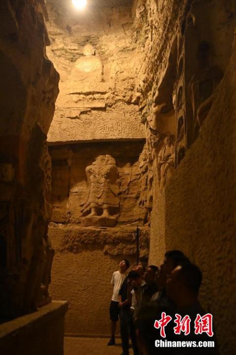 7月15日，游人參觀甘肅省平?jīng)鍪袥艽h百里石窟長廊中的王母宮石窟。百里石窟長廊位于涇川縣境內(nèi)，由512個石窟、5眼窟中石井組成，現(xiàn)存王母宮石窟、鳳凰山石窟、南石窟寺、丈八寺石窟、羅漢洞石窟、太山寺石窟等規(guī)模較大的石窟群，還有數(shù)量眾多的小石窟群。王母宮石窟又名千佛洞，該窟設(shè)計宏大，造像生動，窟內(nèi)擁有造像數(shù)百尊，是較為珍貴的佛教文化遺存。中新社記者 李亞龍 攝</p>
<p>