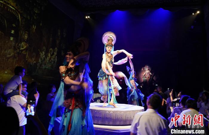 《樂動(dòng)敦煌》是全球首部洞窟式沉浸體驗(yàn)劇，利用真人與數(shù)字影像虛實(shí)交換實(shí)現(xiàn)沉浸式體驗(yàn)。圖為2023年8月28日晚，《樂動(dòng)敦煌》演出。(資料圖)中新社記者 毛建軍 攝