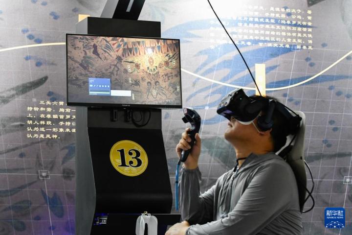 7月22日，游客借助VR設(shè)備沉浸式游覽莫高窟第285窟虛擬場(chǎng)景。新華社記者 郎兵兵 攝